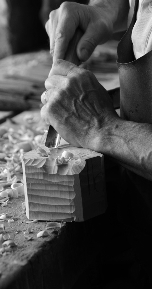 Les mains au travail du sculpteur sur bois